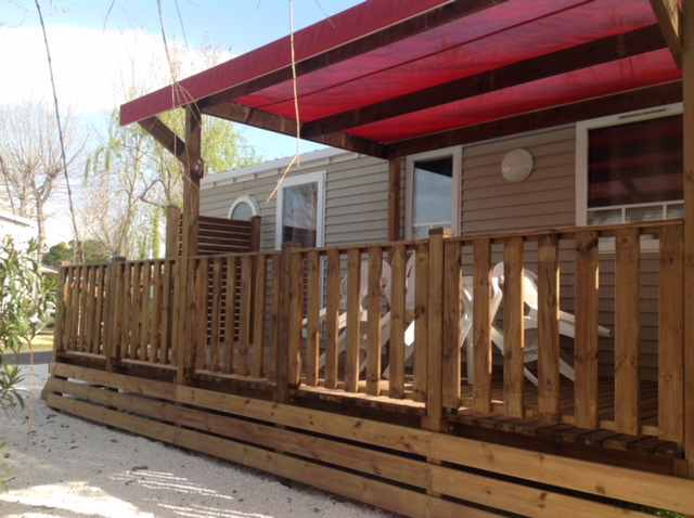 Terrasse de mobil home avec pergola et barrières verticales