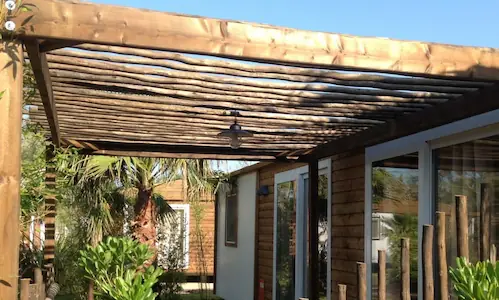 terrasse de mobil home couverte avec pergola au profil bois 3D de type eucalyptus
